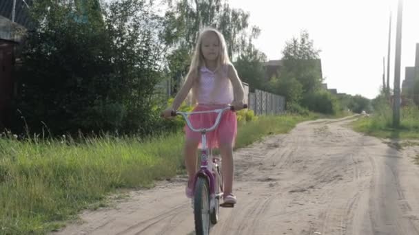 Hermosa, niña monta una bicicleta para niños, bicicleta para niños — Vídeos de Stock