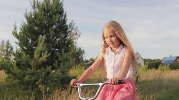 Hermosa, niña monta una bicicleta para niños, bicicleta para niños — Vídeos de Stock