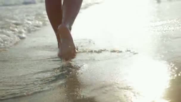 Piedi di una giovane ragazza che cammina su una spiaggia di mare — Video Stock