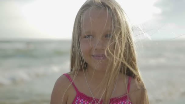 Ritratto di una figlia bionda felice seduta sulla spiaggia — Video Stock