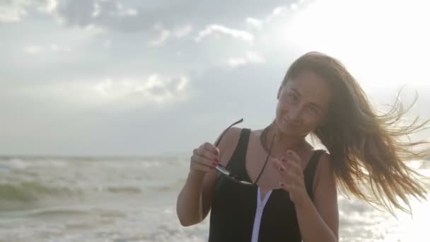 Porträtt av en flicka som promenerar på stranden nära havet — Stockvideo