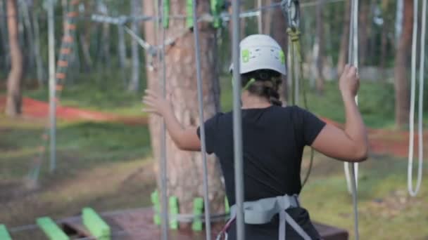 Young beautiful brunette overcomes obstacles in the rope town — Stock Video