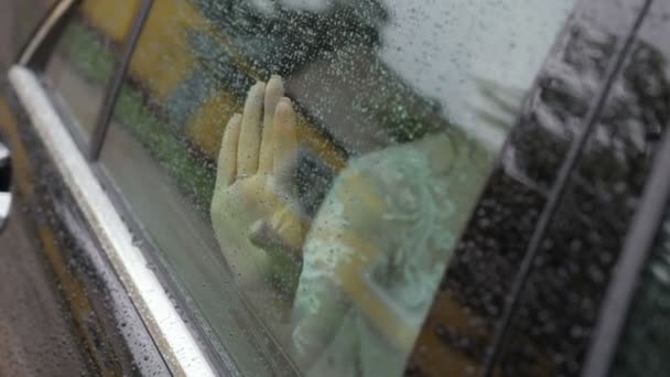 Les filles palme sur le verre humide de la voiture — Video