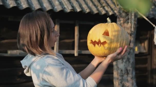 The girl holds Jacks lantern in her hands and shows evil and terrible emotions — Stock Video