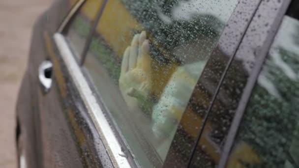 Les filles palme sur le verre humide de la voiture — Video