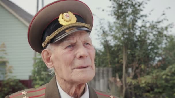 Un vétéran âgé et aux cheveux gris de la Seconde Guerre mondiale et de la grande guerre patriotique en uniforme militaire ferme les yeux. L'homme rappelle les horreurs de la guerre — Video