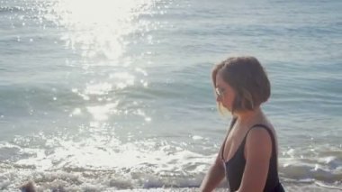 Genç kız plajda denizin kenarında Fitness yapıyor