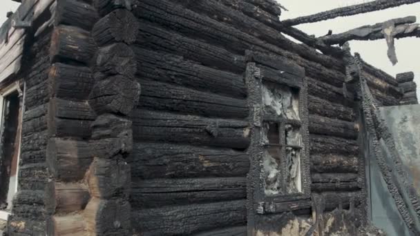 Die Ruinen eines alten Holzhauses, das durch ein Feuer zerstört wurde — Stockvideo