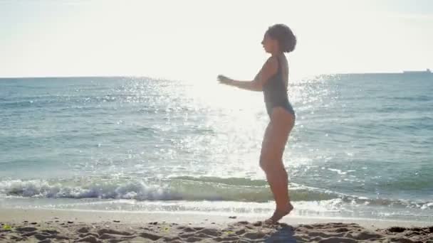 Jeune femme faisant du fitness sur le fond de la mer, l'océan — Video