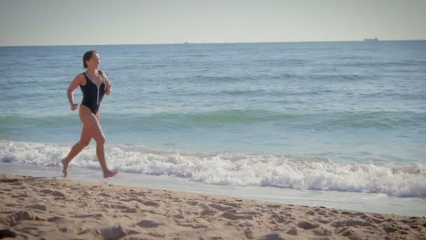 Mladá žena, která dělá fitness na pozadí moře, oceán — Stock video