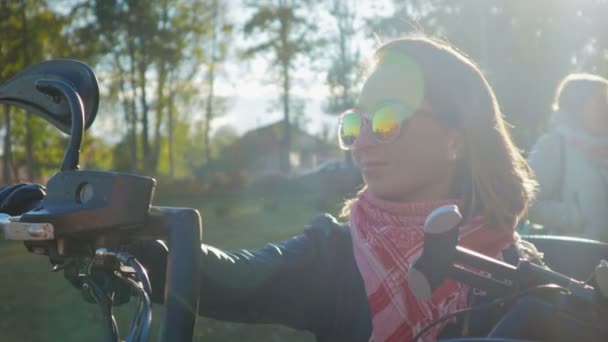Portret van een jong meisje op een rockconcert. Vrouw op de achtergrond van motorfietsen, luisteren naar muziek en gebaren met zijn handen, zingen — Stockvideo