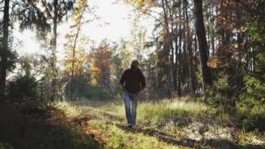 Genç bir adam ormana doğru yürür ve hayat sahiptir
