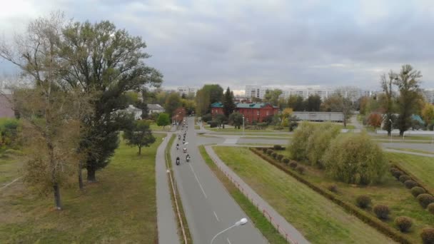 A nézet a levegőből a motorosok lovaglás a város körül egy csomó — Stock videók