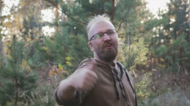 Gözlük ve sakalı bir helezon şeklinde komik, neşeli bir adam portresi. Adamın parmağını yukarı yükseltir ve gibi gösterir