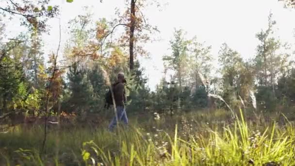 Młody facet, człowiek idzie przez las i cieszy się jesień krajobraz — Wideo stockowe