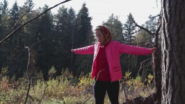 Giovane ragazza rurale che cammina su un tronco, contro la foresta autunnale — Video Stock