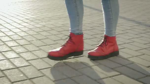 Pés de mulher em botas laranja atravessam a cidade, close-up — Vídeo de Stock