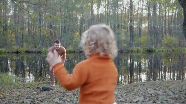 Menino feliz correndo junto ao lago no outono Park — Vídeo de Stock