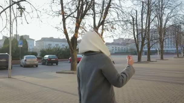 在秋天或春天的城市里, 女人穿着外套走路 — 图库视频影像