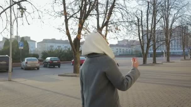 Une femme marche en manteau à l'automne ou au printemps — Video