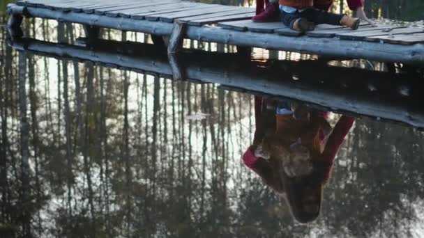 Mãe e filho sentar e brincar no cais perto do lago da floresta — Vídeo de Stock