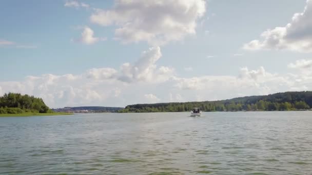 Моторная лодка с людьми, плавающими в заливе — стоковое видео