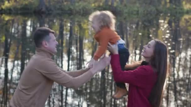 Famiglia felice che si diverte in autunno o primavera nel parco all'aperto con il bel tempo soleggiato — Video Stock