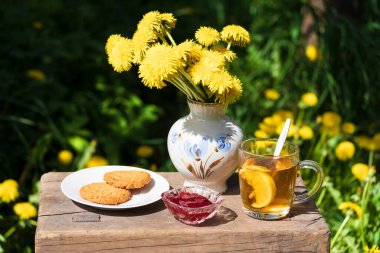 Bahçede çiçeklerle süslenmiş kurabiye ve reçelli çay partisi. Gıda natürel