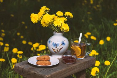 Bahçede çiçeklerle süslenmiş kurabiye ve reçelli çay partisi. Kırsal kesimde yiyecek natürmort