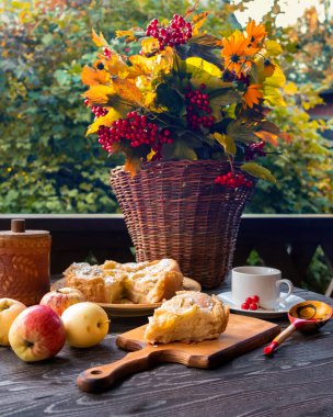 Elmalı turta, çay Viburnum ve sepetinde sarı çiçeklerle kırsal bir retro tarzında sonbahar sakin bir hayattır.