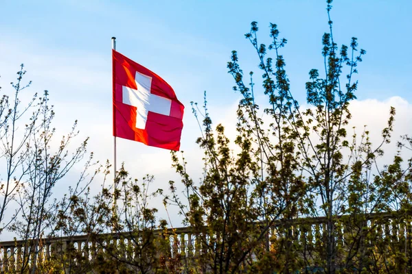 Swiss Confederation, Switzerland national flag waving on blue sky background