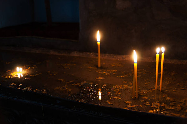 Candle burning brightly close up on the black background