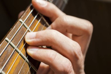 Elini bir akor gitar fretboard üzerinde tutar.