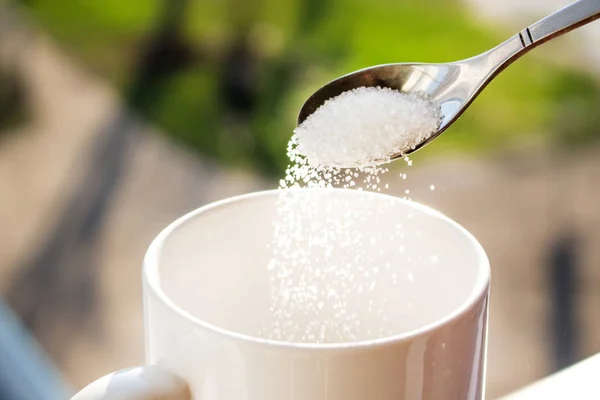 Pour sugar into a mug