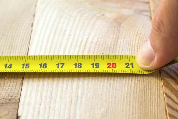 Measure with a tape measure on a wooden board