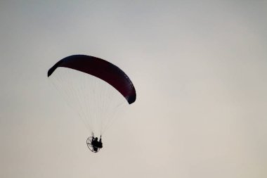 Gökyüzünde bir Yamaçparaşütü üzerinde uçan bir adam