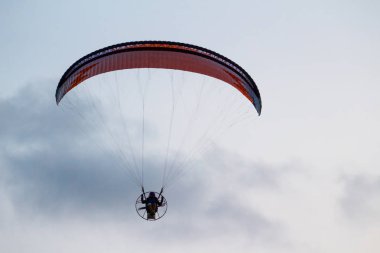 Adam bir yamaçparaşütü deniz ve plaj üzerinde uçuyor