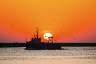 Gemi çembere kuşlara karşı batan güneşin zemin ile Balık tutma