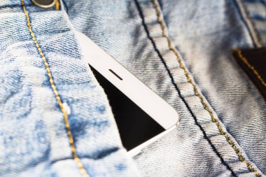 mavi kot pantolon beyaz smartphone yatıyor