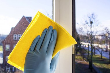 Sarı bir bezle pencere lastik eldiven elinde mendil