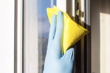 Sarı bir bezle pencere lastik eldiven elinde mendil