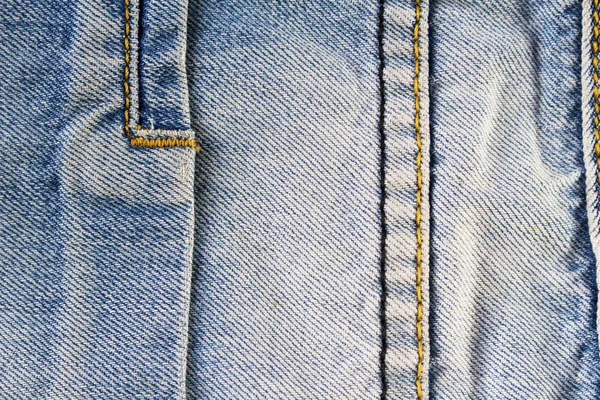 seams on a blue denim fabric background texture