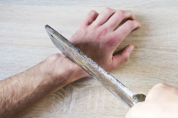 to cut off a hand with an ax