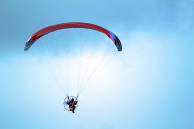 Adam bir yamaçparaşütü deniz ve plaj üzerinde uçuyor