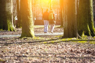 Kız adamla parkta, tonda yürüyor