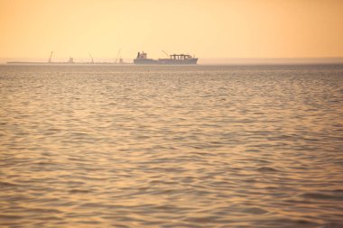 ufukta turuncu büyük bir gemi silueti tonda