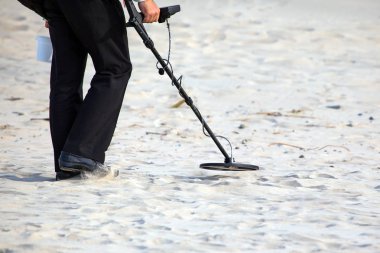 Plajda metal dedektörlü bir adam var.