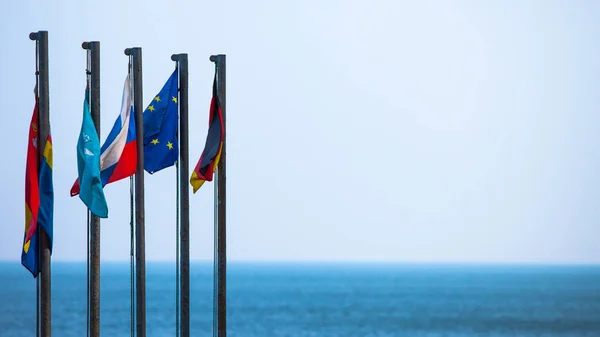 欧州連合および旗竿の空を背景に国の国旗 — ストック写真
