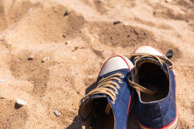 kum üzerinde mavi spor ayakkabı