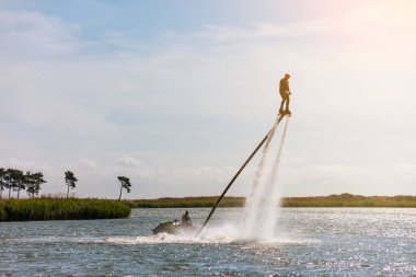 bir adam tonda bir flyboard güneşli bir günde, güneşli bir gölde biniyor
